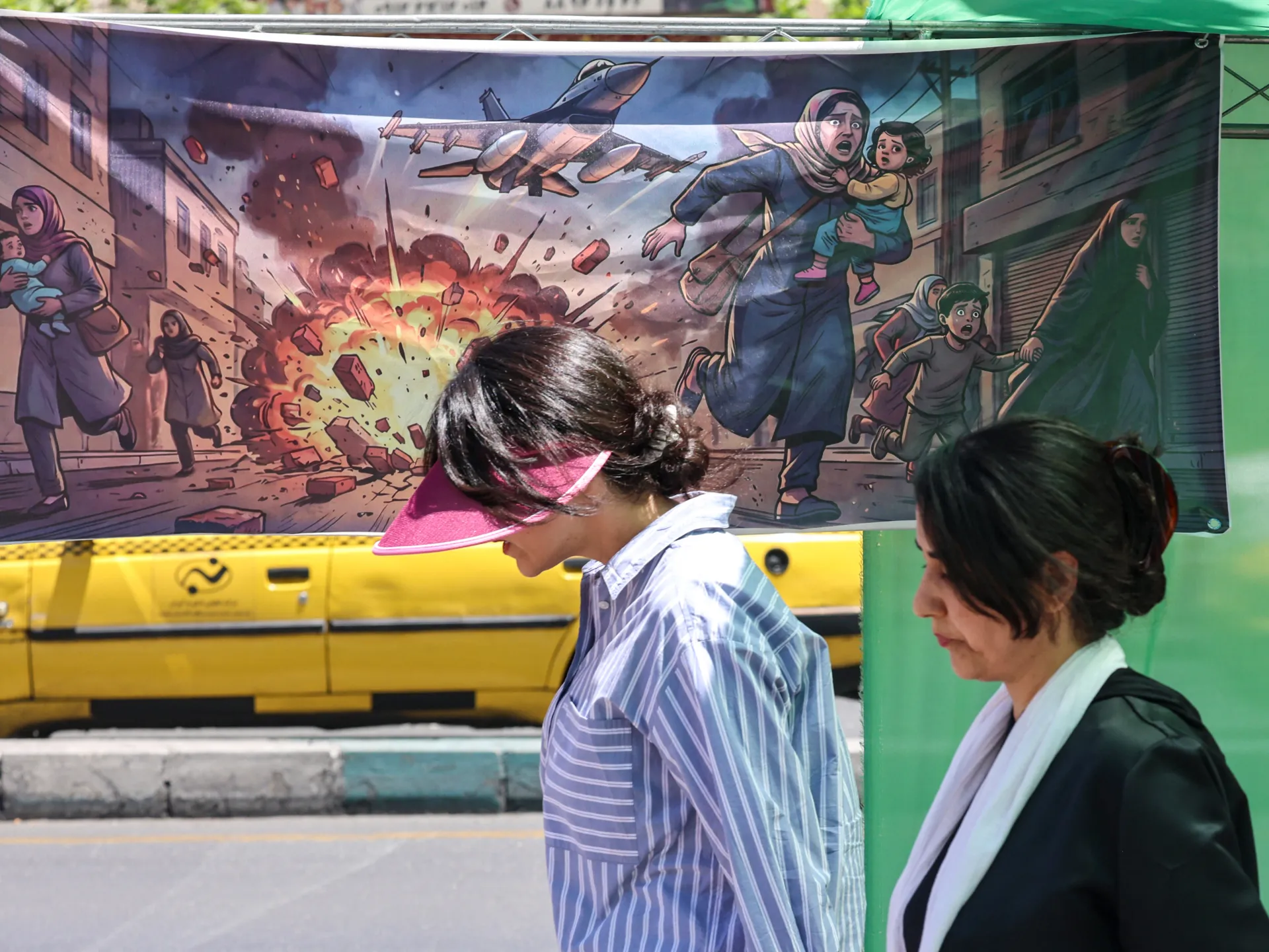 A banner depicts US-Israeli attacks on Iran in the capital, Tehran [File: Atta Kenare/AFP]