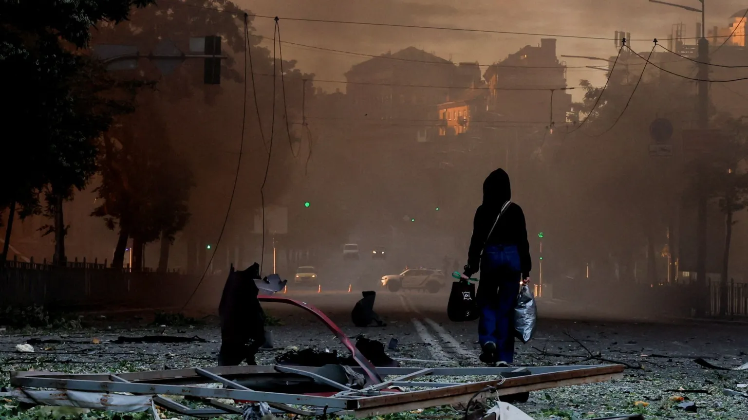A resident walks through debris-covered street in Kyiv after Russian bombardment struck over 40 locations across the capital.