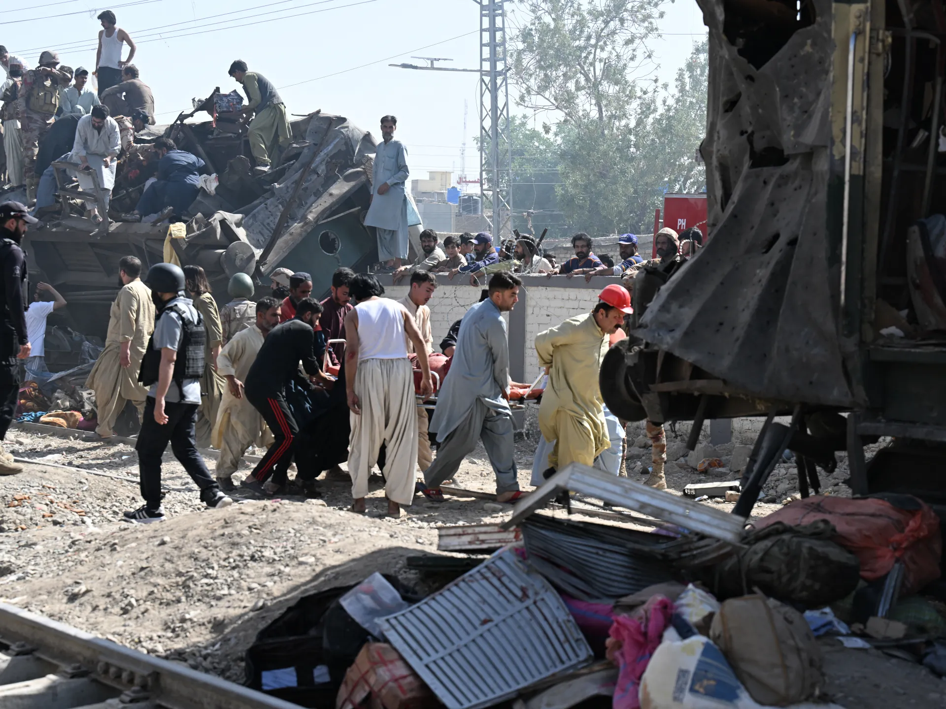 Security personnel and residents rescue injured blast victims from derailed carriages after an explosion targeted a train in Quetta, in Pakistan's Balochistan province, on May 24, 2026 [AFP]