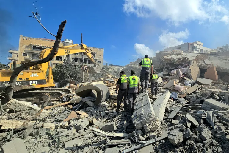 Lebanese civil defence workers search through the rubble of a building following an Israeli attack at dawn in the southern Lebanese area of al-Hosh, near the coastal city of Tyre [AFP]
