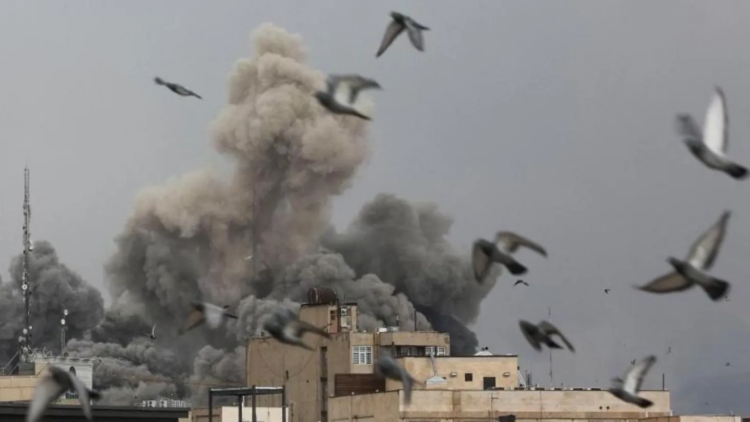 Reuters An explosion from a building in Tehran as birds fly away.