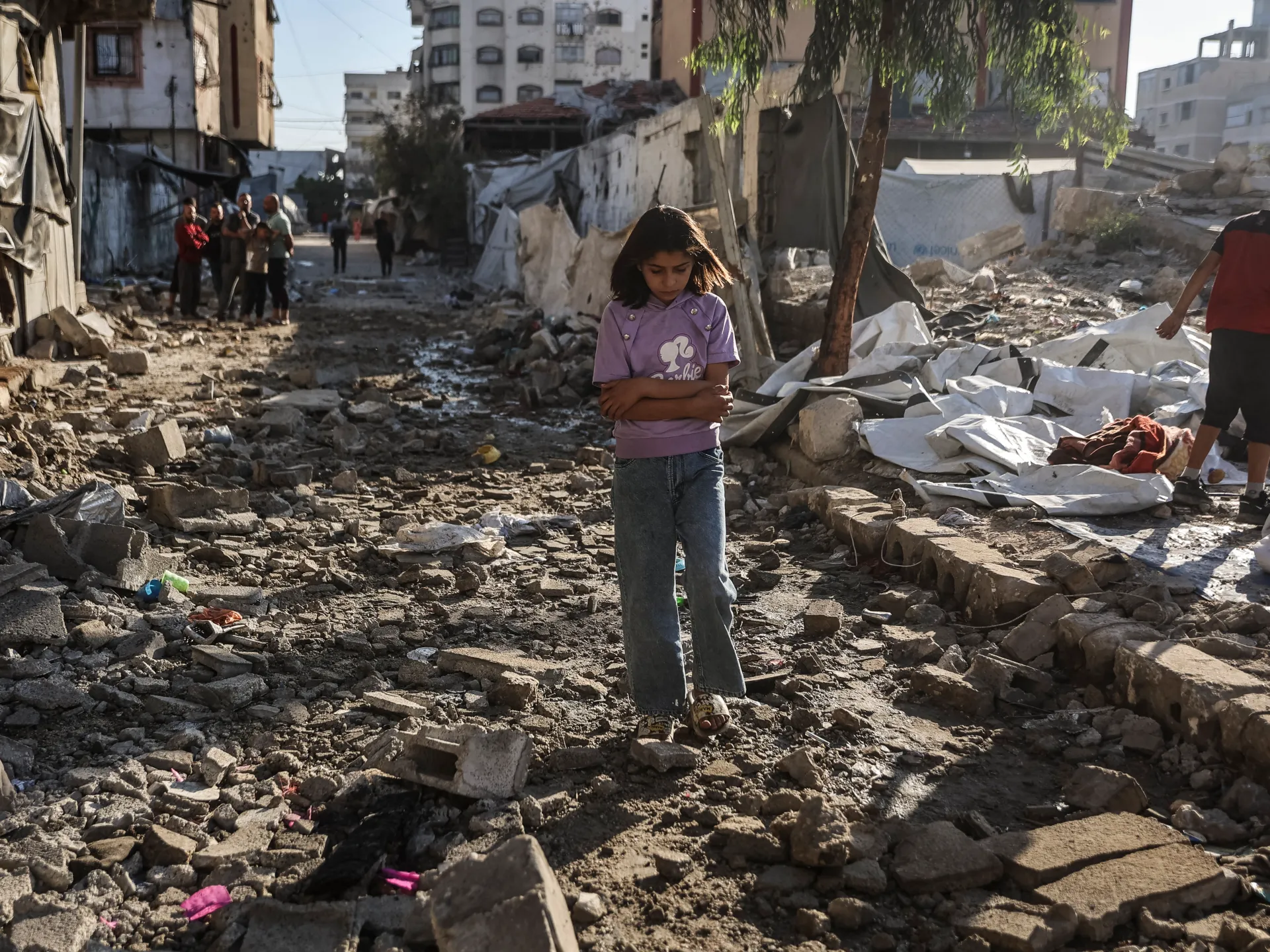 A Palestinian girl in the rubble of an overnight Israeli attack on structures and tents for displaced families in Gaza City [AFP]