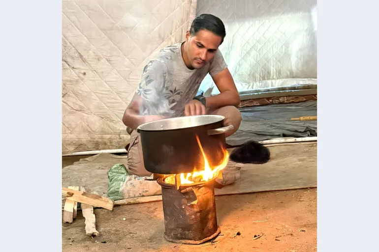 Muhannad Qishta in displacement tent, unable to visit graves of sisters lost in Gaza's near-total urban destruction.