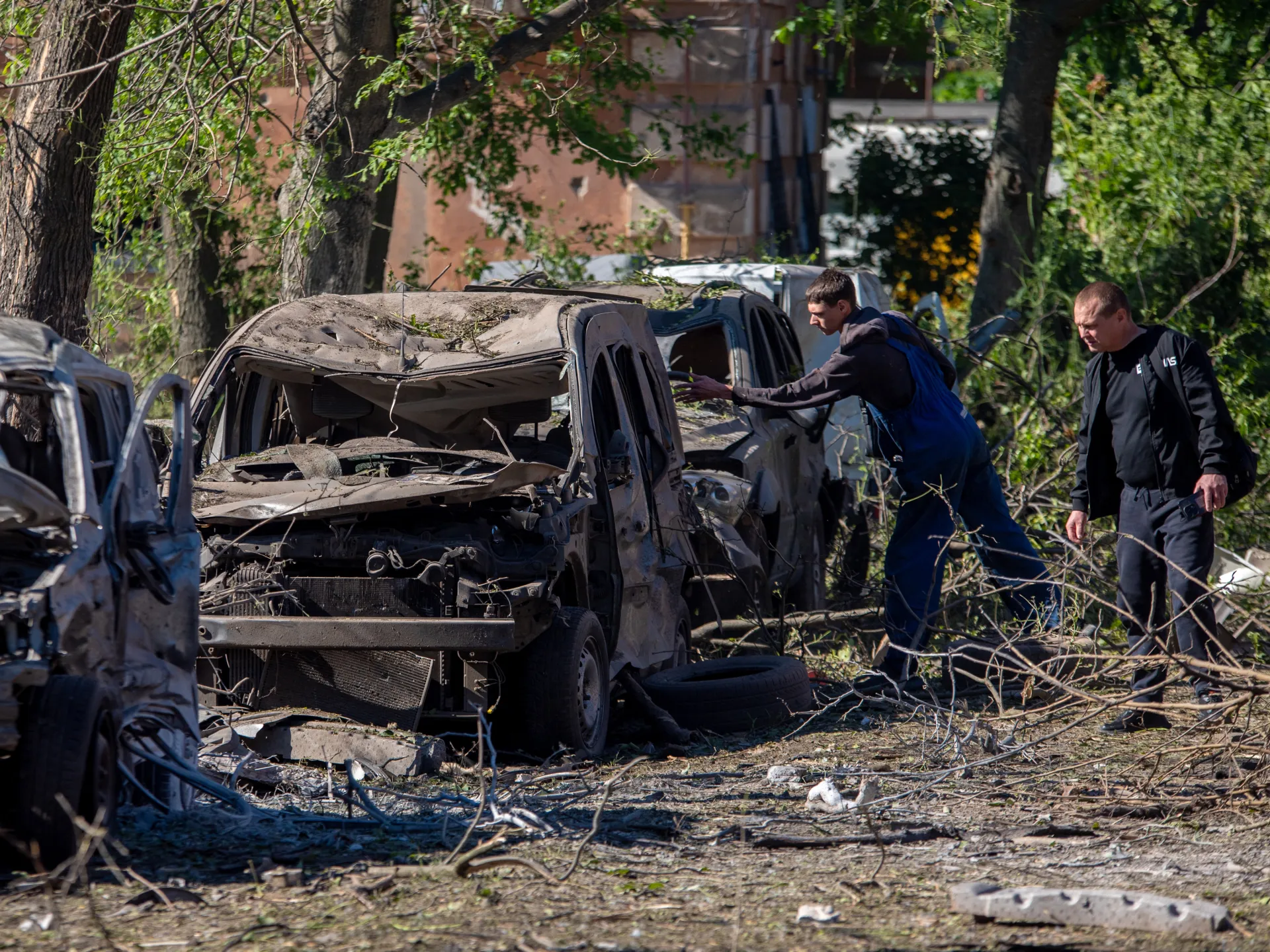 Two men inspect destroyed cars at the site of an air attack in Dnipro on June 2, 2026, amid the Russian invasion of Ukraine [AFP]
