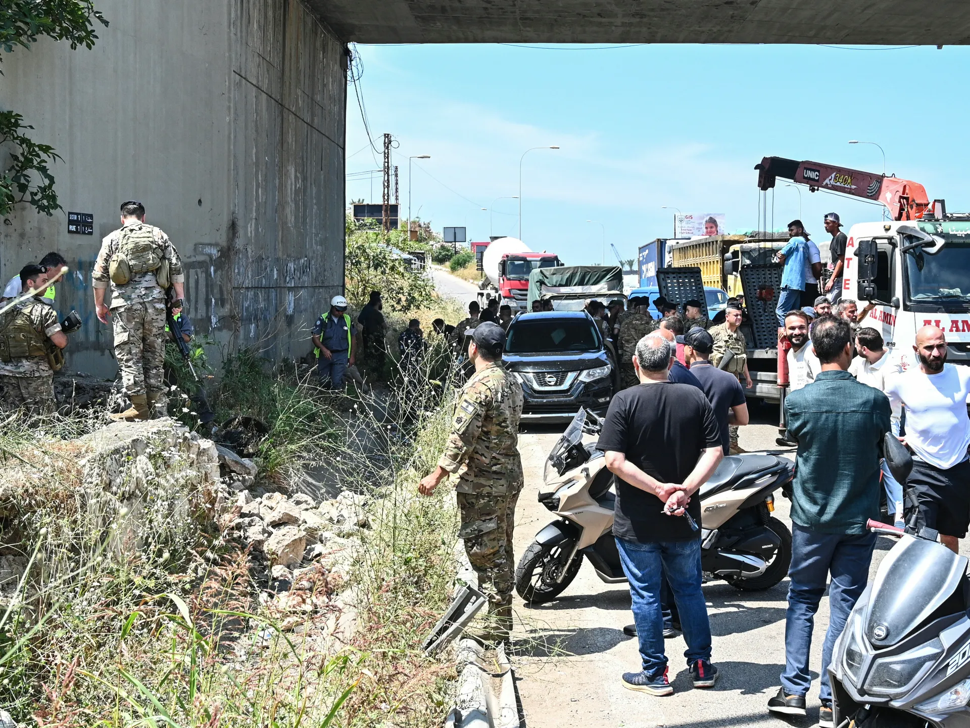 Lebanese soldiers and first reponders inspect the site of an Israeli drone strike near a vehicle on the Khaldeh highway at the southern entrance to Beirut, June 3 [AFP]