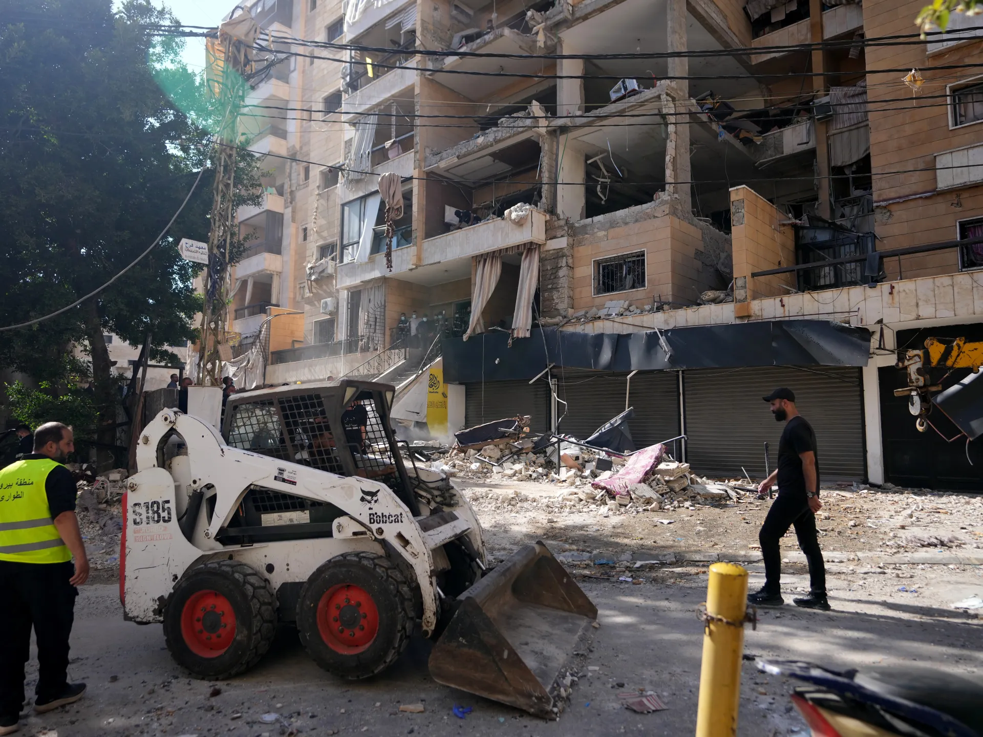 Municipality workers remove the rubble of destroyed apartments that where hit by an Israeli airstrike in Dahiyeh, Beirut's southern suburb [Hassan Ammar/AP Photo]