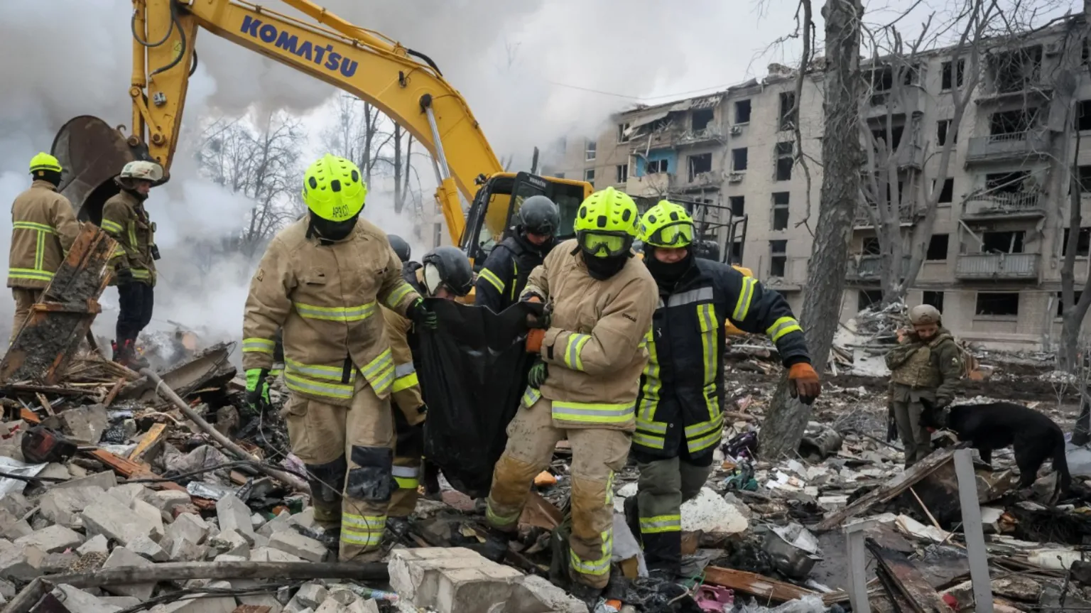 Rescuers carry a bag with the body of a person found under debris