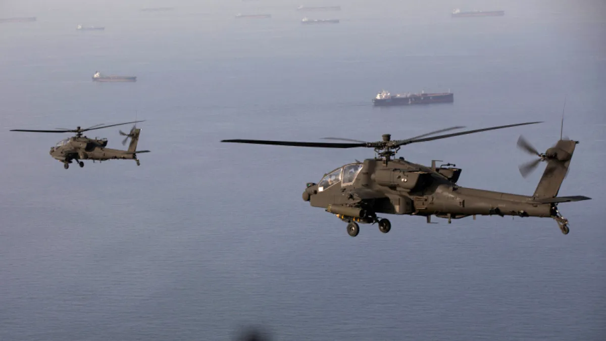 A pair of AH-64 Apache helicopters fly above the Strait of Hormuz during a patrol on April 17 [CENTCOM/AFP]