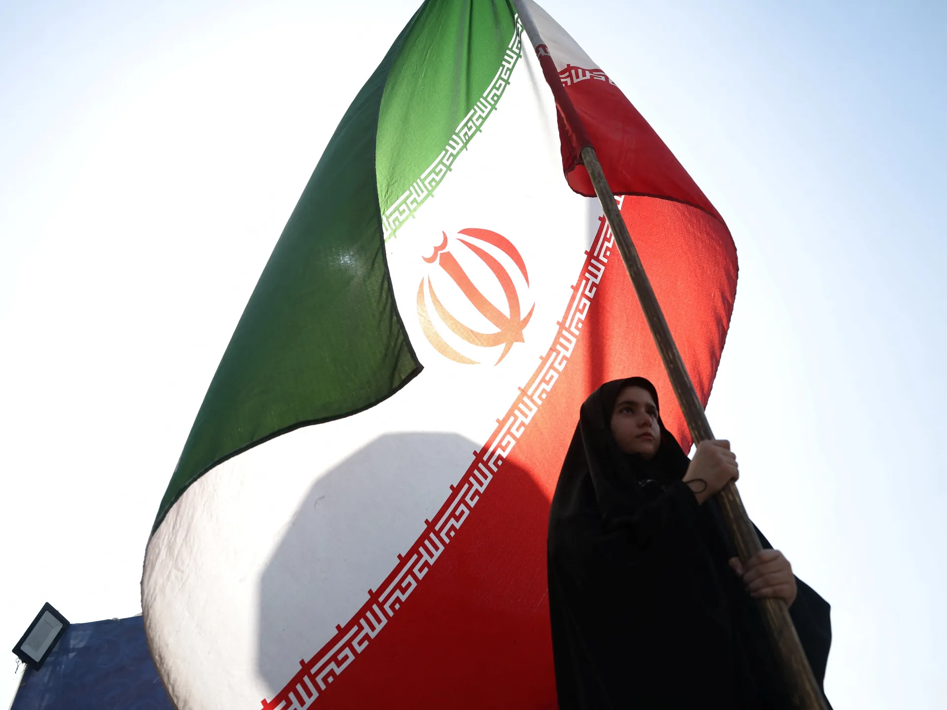 A woman holds an Iranian flag on a street in Tehran, Iran, June 10, 2026 [Majid Asgaripour/WANA via Reuters]