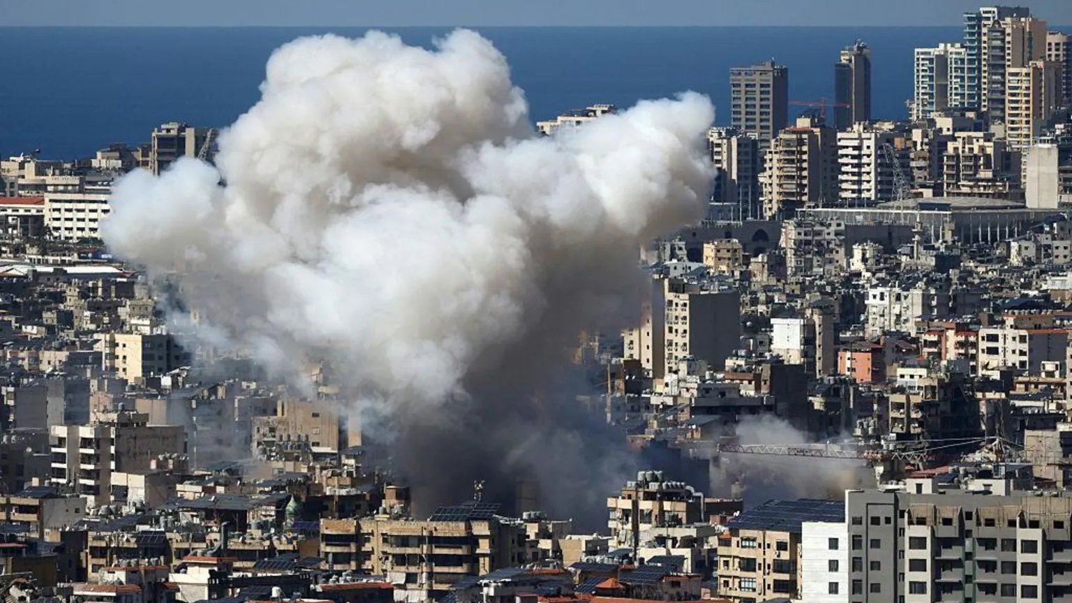 AFP via Getty Images Smoke rises after an air strike in the suburbs of Lebanon's capital Beirut on 9 March. The area is densely populated with high rise buildings.