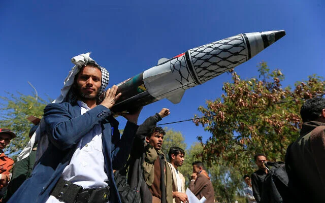 A man carries a mock missile during a rally by university students and faculty denouncing strikes on Yemen and in solidarity with Palestinians, in the Houthi-controlled capital Sanaa on January 1, 2025. (Mohammed HUWAIS / AFP)