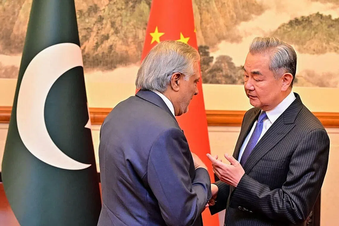 China's Foreign Minister Wang Yi (R) speaking with his Pakistani counterpart Ishaq Dar in Beijing on March 31.