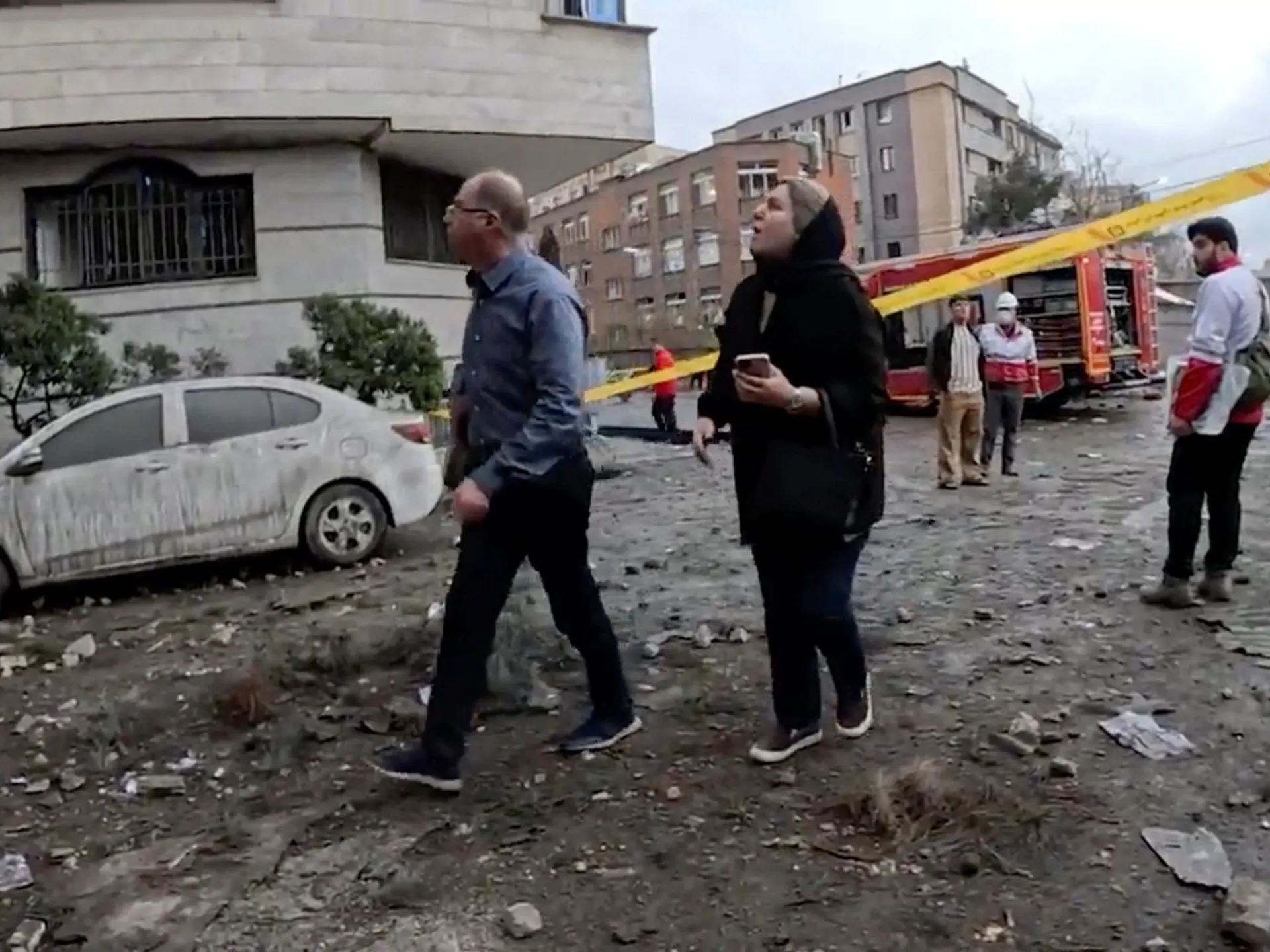 People walk near a cordoned-off area, as members of the Iranian Red Crescent Society work at the site of a reported strike, amid the US-Israeli war on Iran [Reuters]