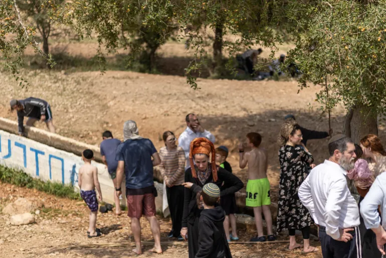Israeli settlers at a water slide in occupied West Bank village of Ras Ein al-Auja amid escalating regional violence.