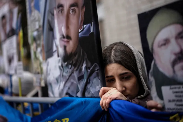 A woman awaits news of a missing relative during a prisoner of war exchange with Ukrainian forces.
