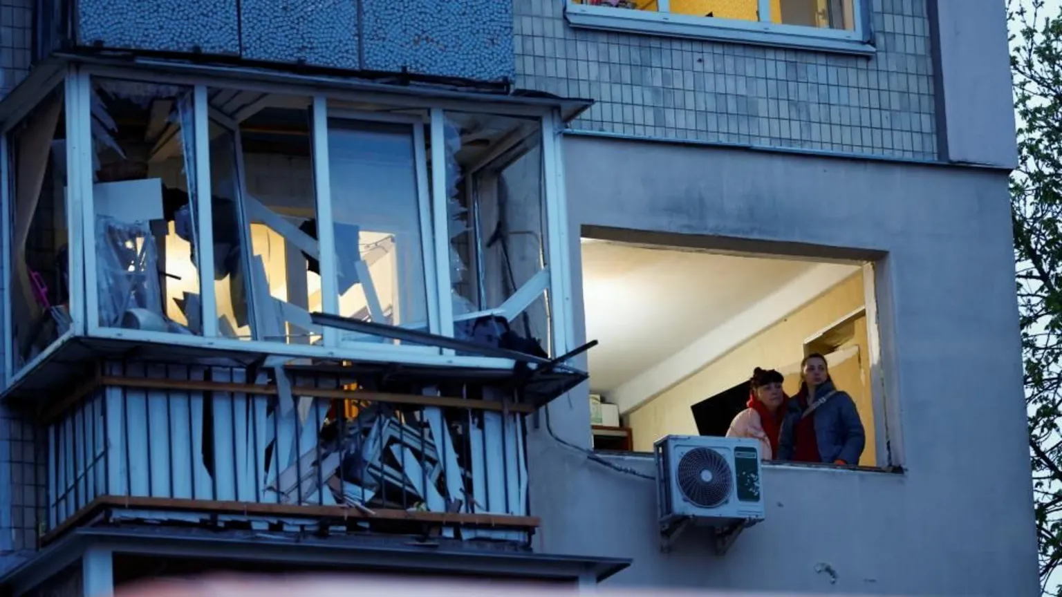 Residents survey damage to apartment building hit during overnight Russian drone and missile barrage on Kyiv.