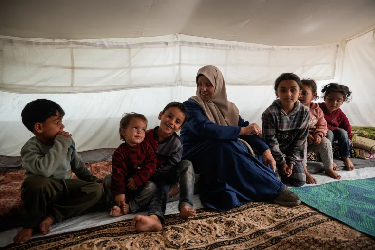Inaam sits with her six grandchildren, whose father Mahmoud has been imprisoned for over two years in Israeli custody.