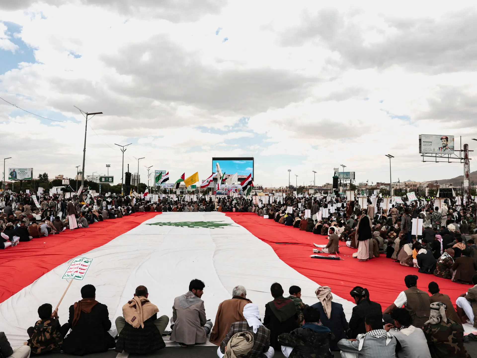Houthi supporters in Yemen rally round a Lebanese flag during a demonstration in Sanaa to show solidarity with Lebanon [Khaled Abdullah/Reuters]