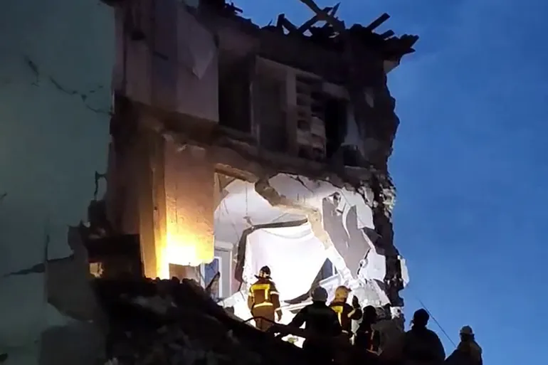 Emergency responders search through rubble of a heavily damaged apartment building hit during intensified Russian missile and drone attacks.