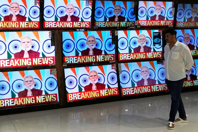 An Indian citizen watches Prime Minister Narendra Modi's address regarding the Russia-India military pact.
