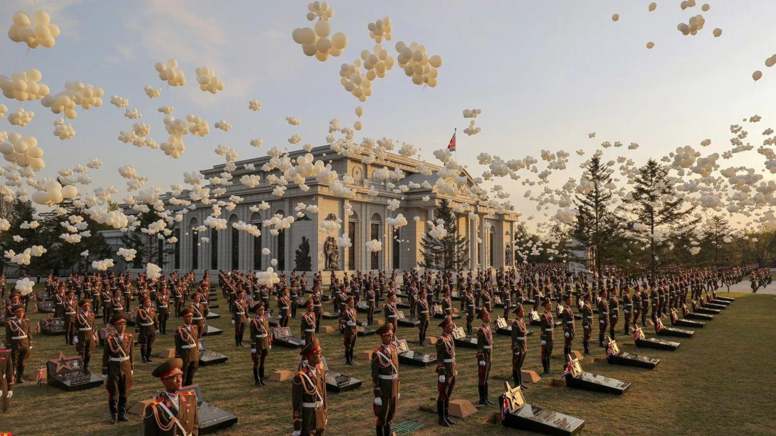 Military jets perform flyover as white balloons are released during the memorial dedication ceremony in Pyongyang.