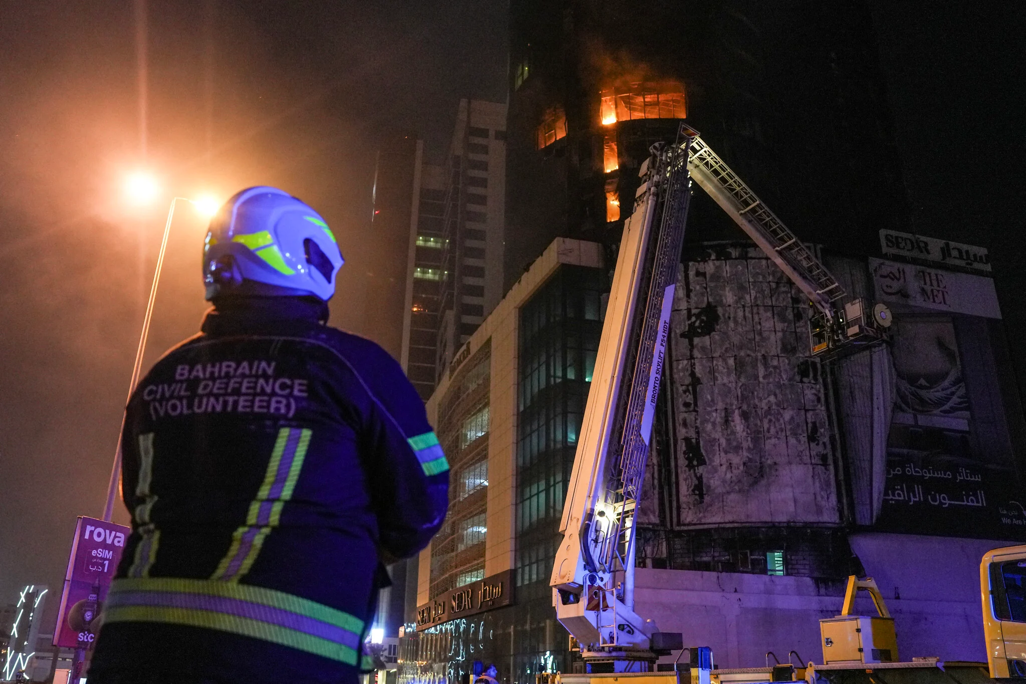 Emergency personnel work to extinguish a fire in a building after an Iranian strike in Manama, Bahrain on February 28, 2026. (Fadhel Madan/ AFP)