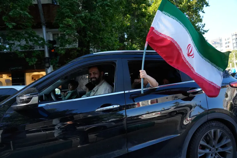 Iranian child holds national flag in Tehran as tensions escalate between Iran and United States over Hormuz incident.
