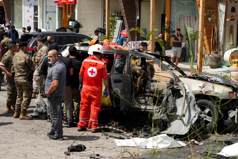 Rescuers work at the site of an Israeli drone strike on a car in Jiyeh, Lebanon, killing at least eight people.