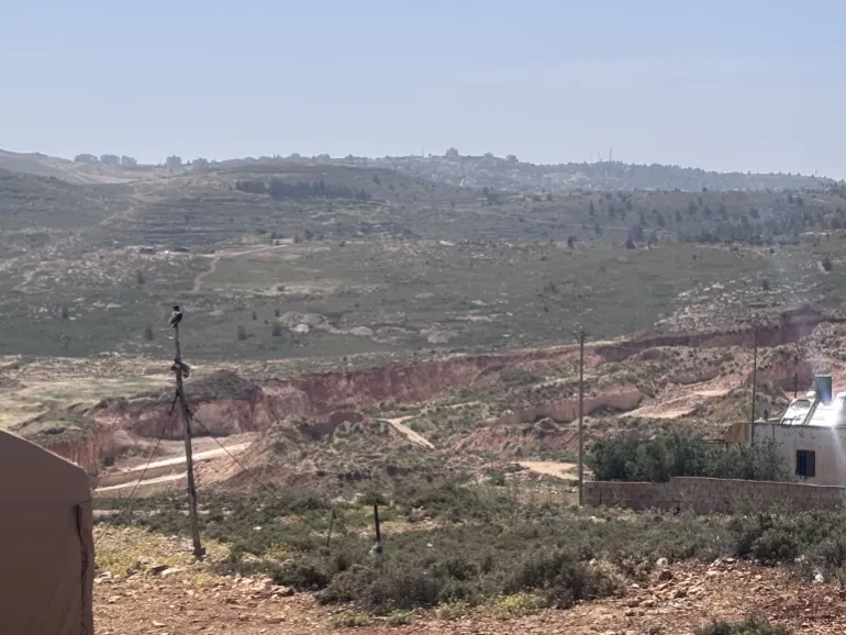 An illegal Israeli outpost overlooks Abu Najjeh's tent in Rammun, part of ongoing settler encroachment.