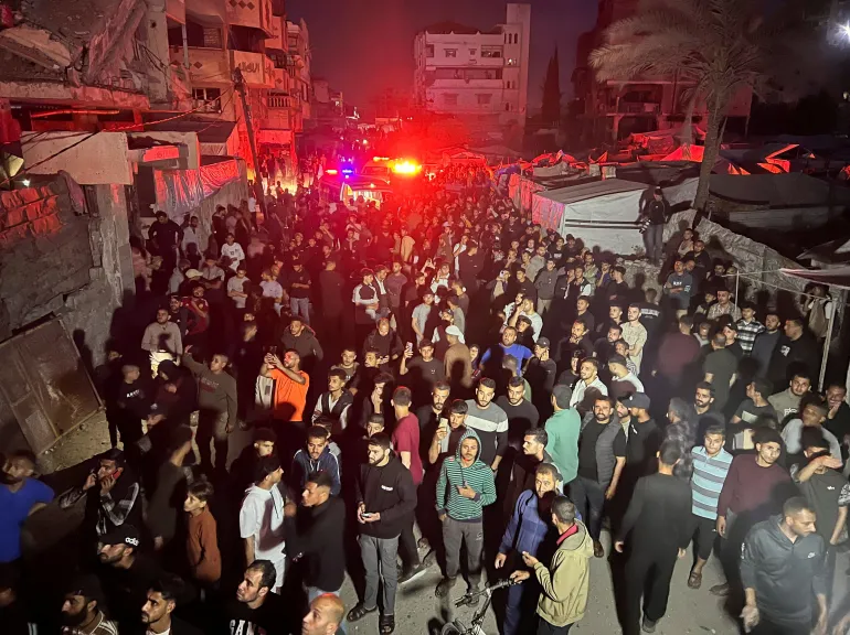 Gathering around a residential apartment as a fire burns after Israeli shelling, according to the Ministry of Health, in Gaza City, May 15, 2026. [Ebrahim Hajjaj/Reuters]